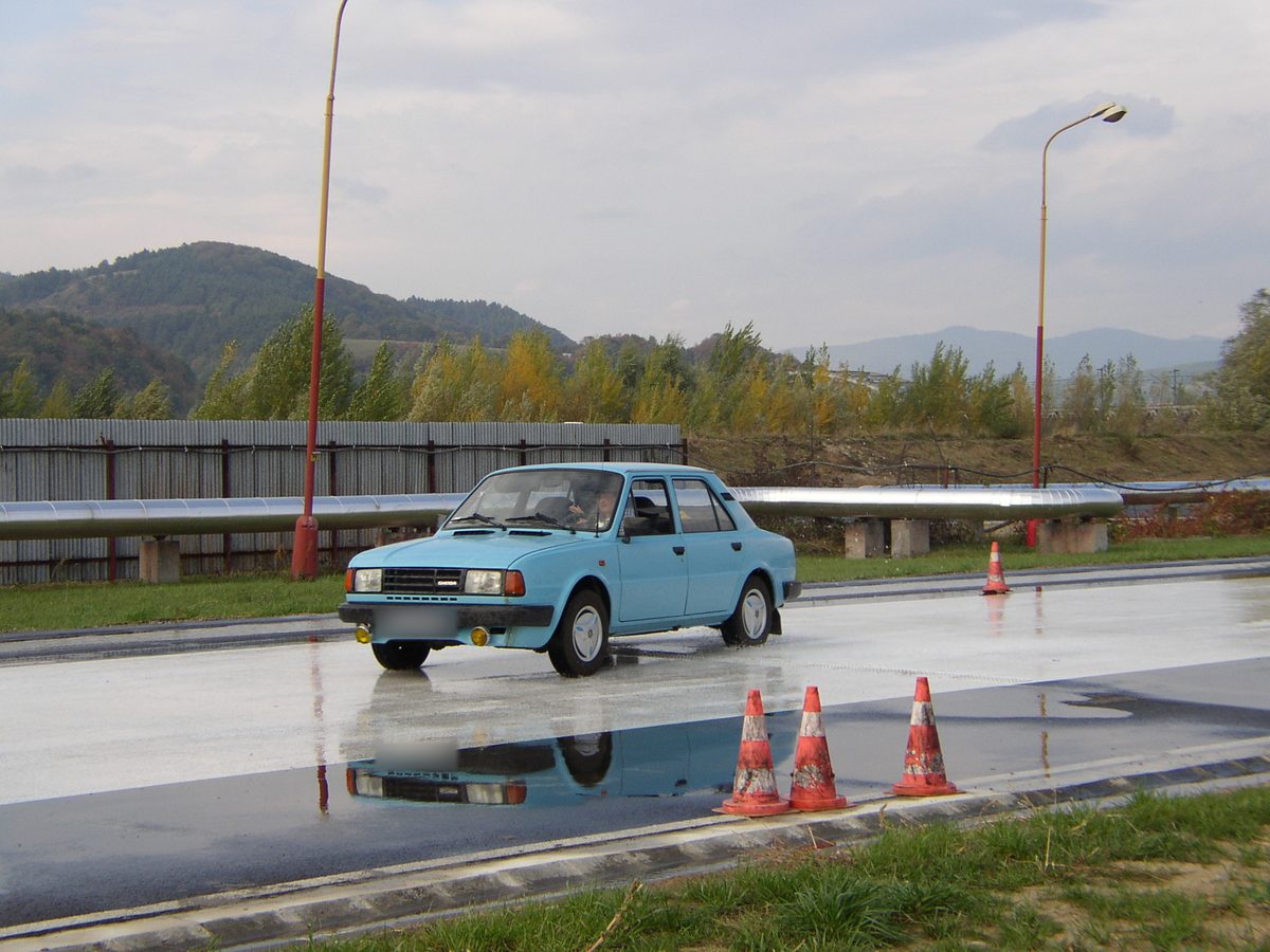 Modrá Škoda na mokrej ploche medzi kužeľmi